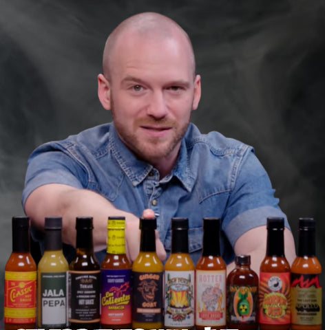 Sean Evans at the Hot Ones table, with The Original Goat in the sauce lineup