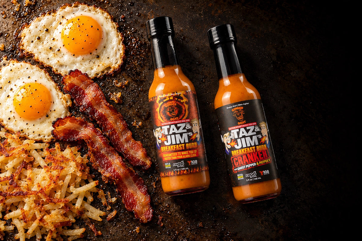 Breakfast Burn and Cranker beside bacon, eggs and hash browns on a griddle
